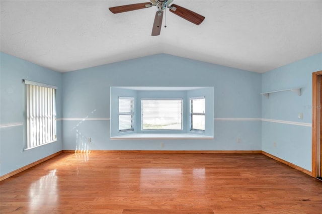 empty room featuring lofted ceiling, light hardwood / wood-style floors, and ceiling fan