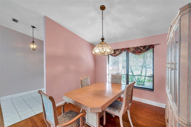 dining room with vaulted ceiling and light wood-type flooring