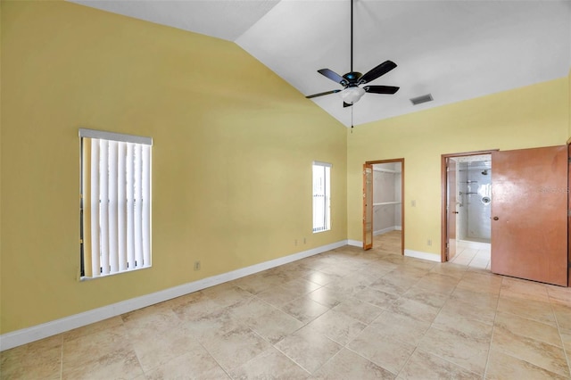 unfurnished bedroom with ensuite bath, high vaulted ceiling, light tile patterned flooring, a walk in closet, and a closet