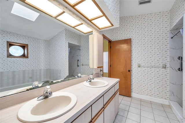 bathroom with tile patterned flooring, vanity, and walk in shower