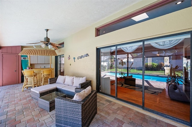 view of patio with bar, ceiling fan, and a textured ceiling