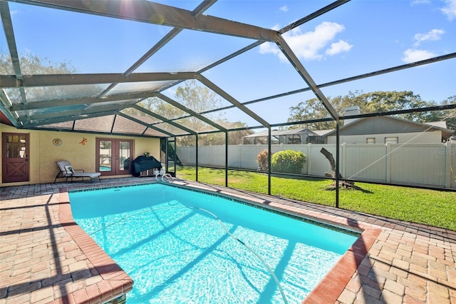 view of swimming pool featuring a yard, a lanai, a patio area, and french doors