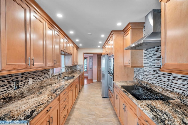 kitchen featuring appliances with stainless steel finishes, tasteful backsplash, sink, dark stone counters, and wall chimney exhaust hood