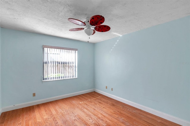 empty room featuring a textured ceiling, light hardwood / wood-style flooring, and ceiling fan