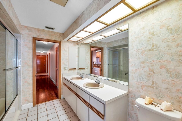 full bathroom featuring vanity, tile patterned floors, shower / bath combination with glass door, and toilet