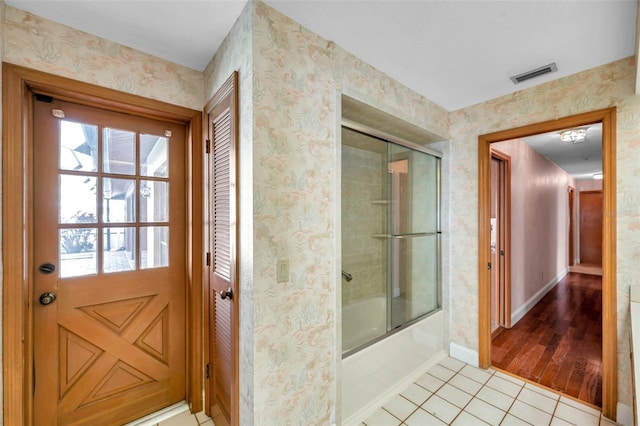 bathroom featuring tile patterned floors and shower / bath combination with glass door