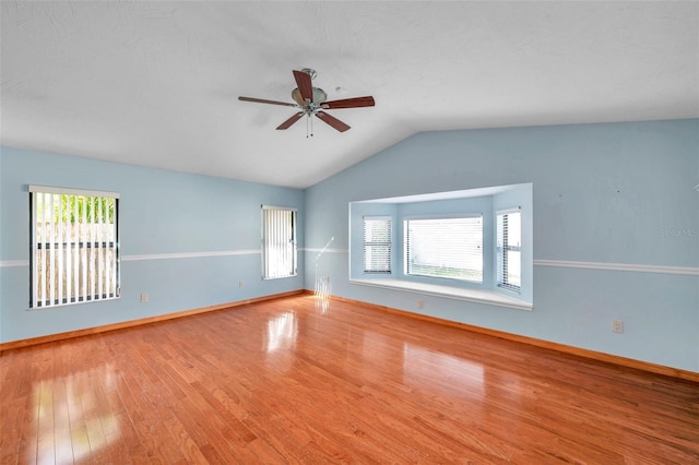 spare room featuring wood-type flooring, lofted ceiling, and ceiling fan