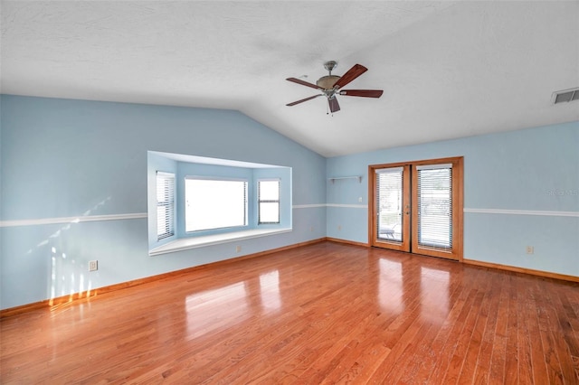 unfurnished room featuring vaulted ceiling, a textured ceiling, ceiling fan, and light hardwood / wood-style flooring