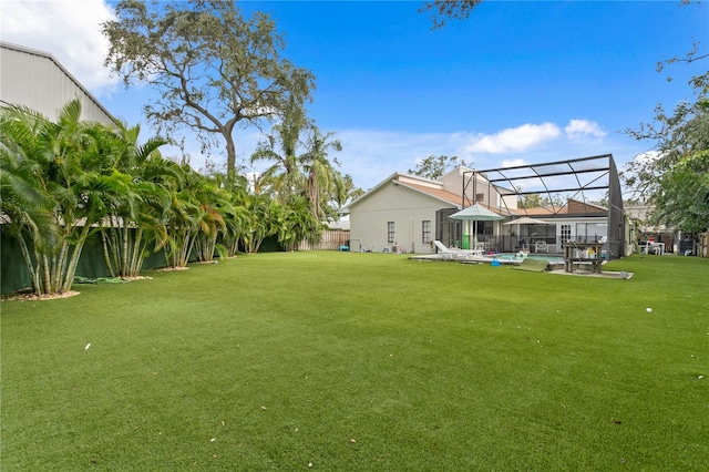 view of yard with a lanai and a swimming pool