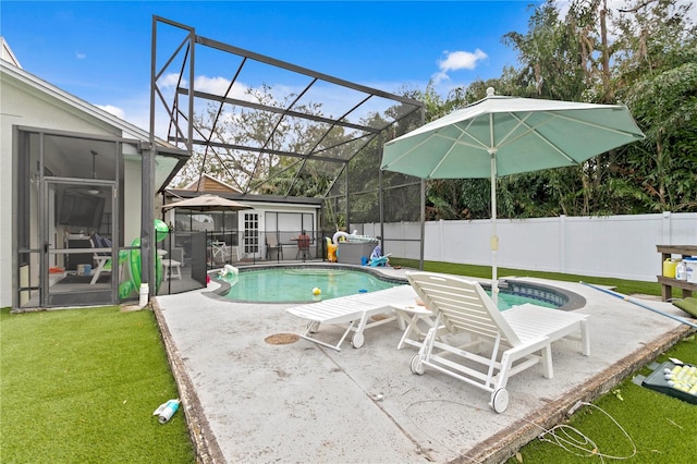 view of pool featuring glass enclosure, a patio area, a lawn, and a sunroom