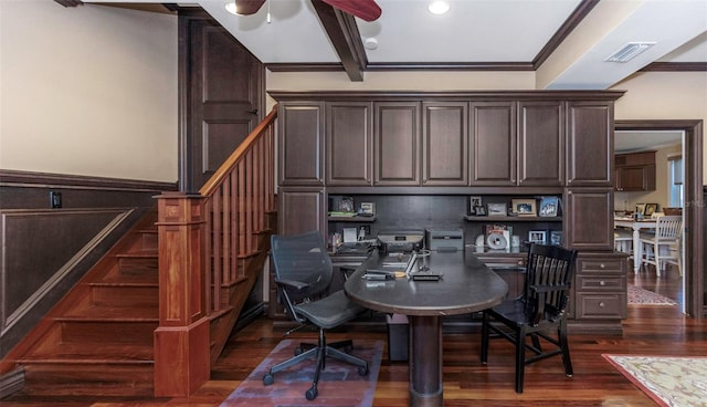 office with built in desk, ceiling fan, beam ceiling, crown molding, and dark wood-type flooring