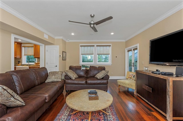 living room with dark wood-type flooring, ceiling fan, and crown molding