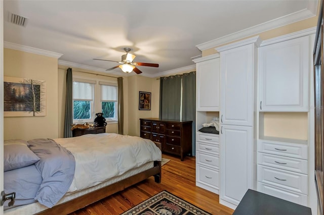 bedroom featuring ornamental molding, light wood-type flooring, and ceiling fan