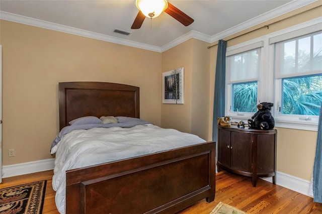 bedroom with ornamental molding, light wood-type flooring, and ceiling fan