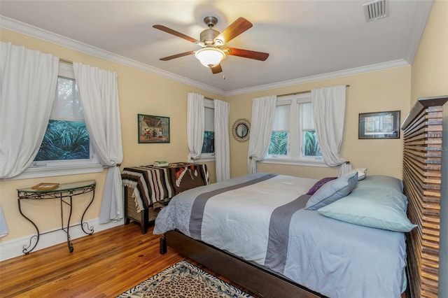 bedroom featuring wood-type flooring, ceiling fan, and crown molding