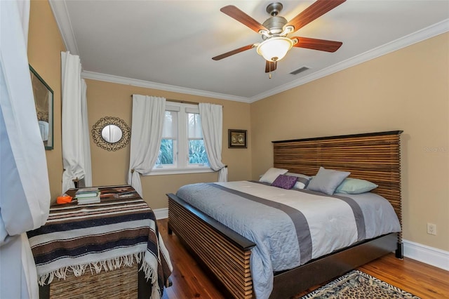 bedroom with crown molding, dark hardwood / wood-style floors, and ceiling fan