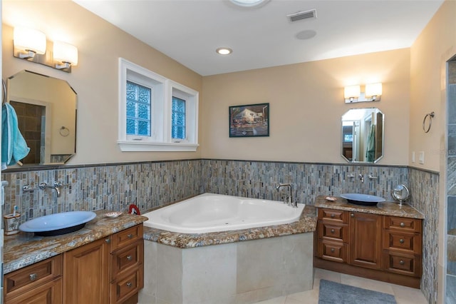 bathroom featuring a bathing tub, tile patterned flooring, and vanity