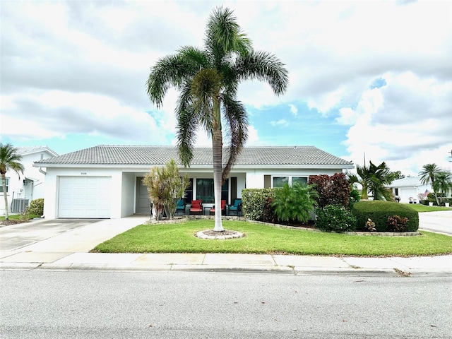 view of front of property with a front yard, cooling unit, and a garage