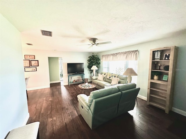 living room with dark hardwood / wood-style flooring, a textured ceiling, and ceiling fan