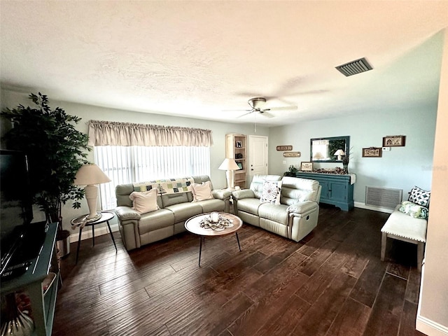 living room with a textured ceiling, dark hardwood / wood-style flooring, and ceiling fan