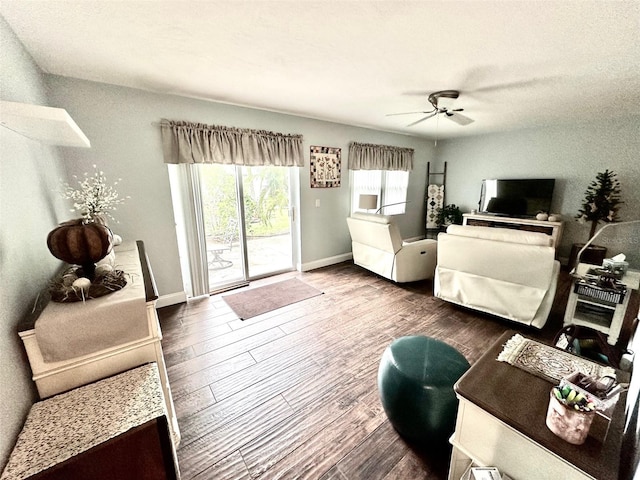 living room featuring dark wood-type flooring and ceiling fan