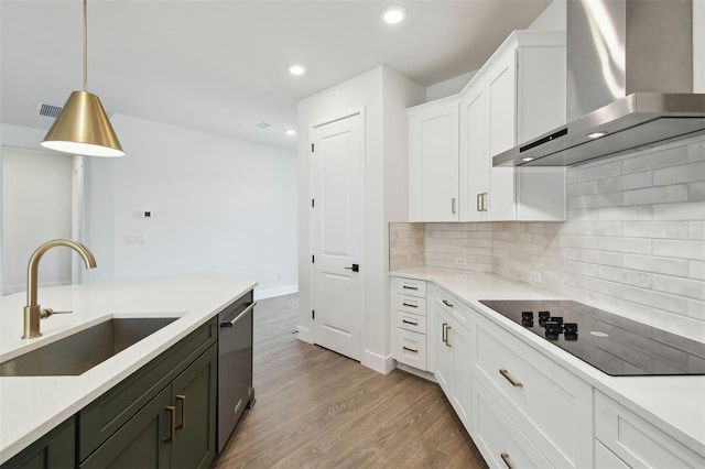 kitchen with wall chimney exhaust hood, sink, white cabinetry, decorative light fixtures, and black electric cooktop