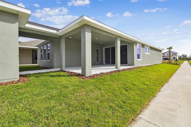 rear view of house with a lawn and a patio area