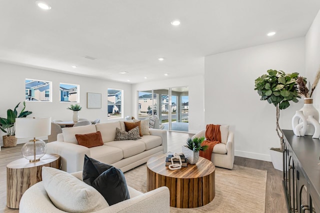 living room featuring recessed lighting, light wood-type flooring, and baseboards