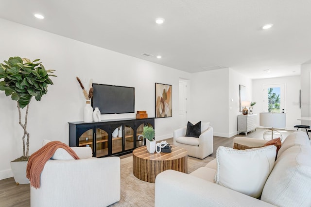 living area with light wood-style flooring, baseboards, and recessed lighting
