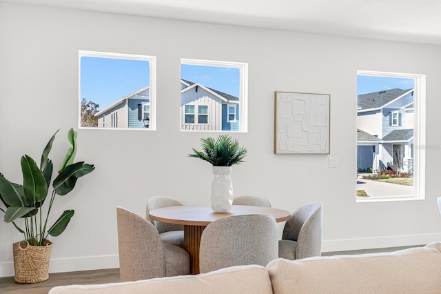 dining room featuring baseboards, wood finished floors, and healthy amount of natural light