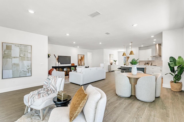 living room featuring recessed lighting, wood finished floors, and baseboards