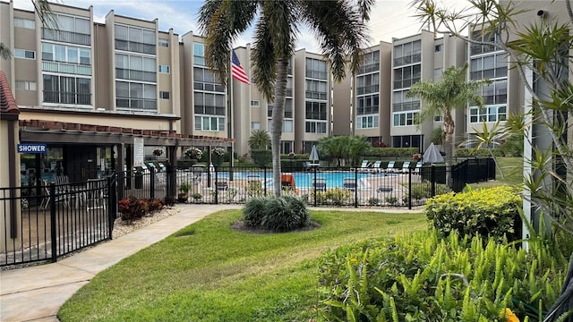 view of community featuring a pool and a yard