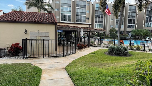 view of community featuring a swimming pool and a lawn