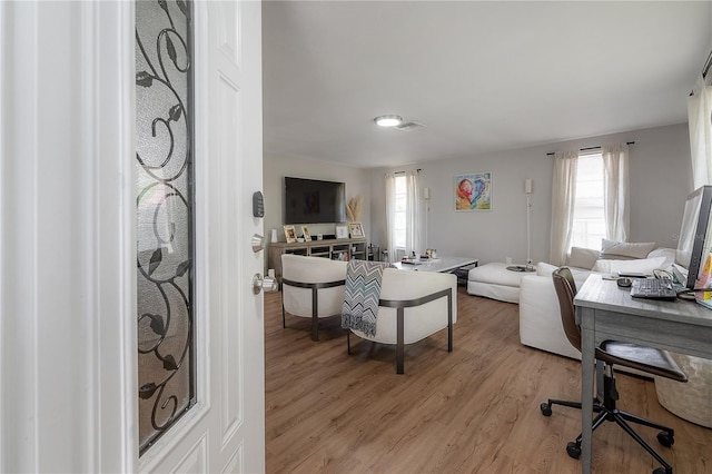 home office with light hardwood / wood-style flooring