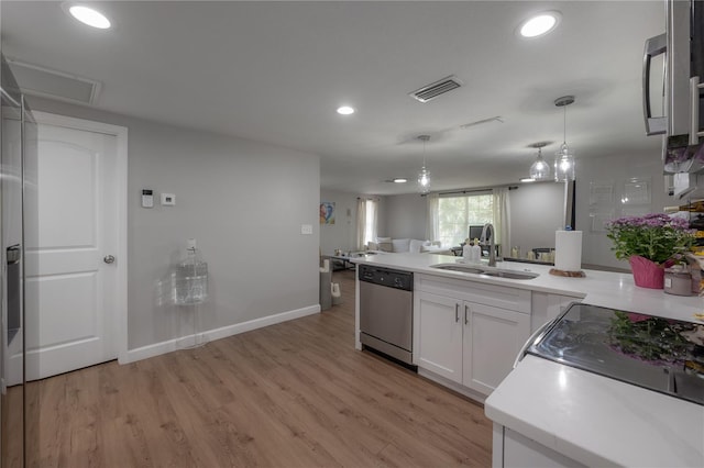 kitchen with white cabinets, sink, stainless steel dishwasher, light wood-type flooring, and decorative light fixtures