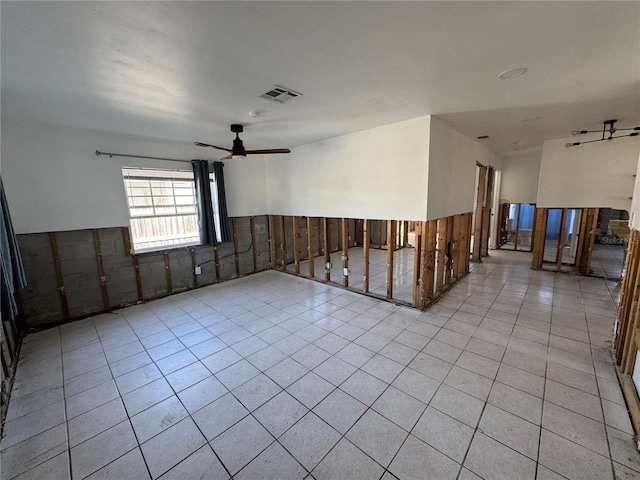 tiled spare room with ceiling fan