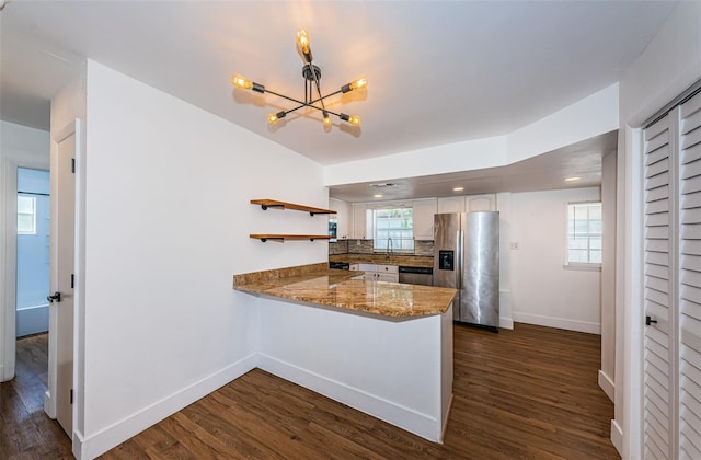 kitchen featuring appliances with stainless steel finishes, decorative backsplash, white cabinets, dark wood-type flooring, and kitchen peninsula