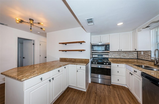 kitchen with stainless steel appliances, sink, kitchen peninsula, dark hardwood / wood-style floors, and white cabinets