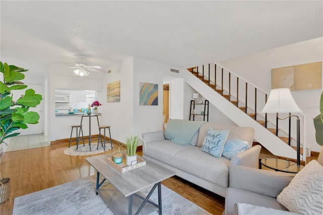 living room with light hardwood / wood-style floors and ceiling fan