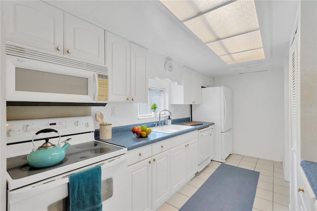 kitchen featuring light tile patterned flooring, white appliances, white cabinetry, and sink