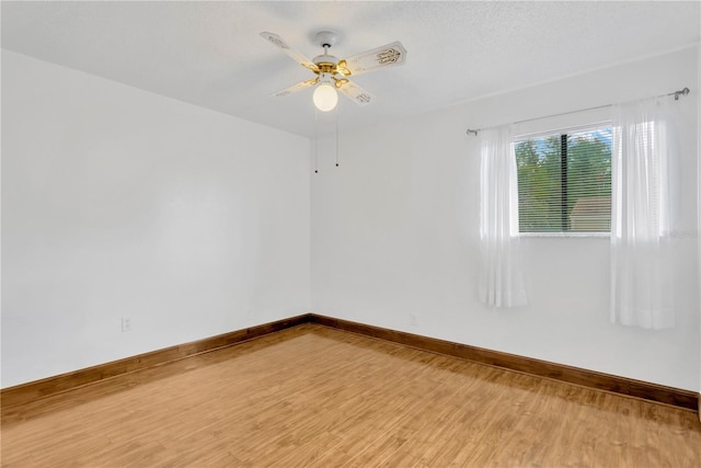 empty room featuring ceiling fan, hardwood / wood-style floors, and a textured ceiling