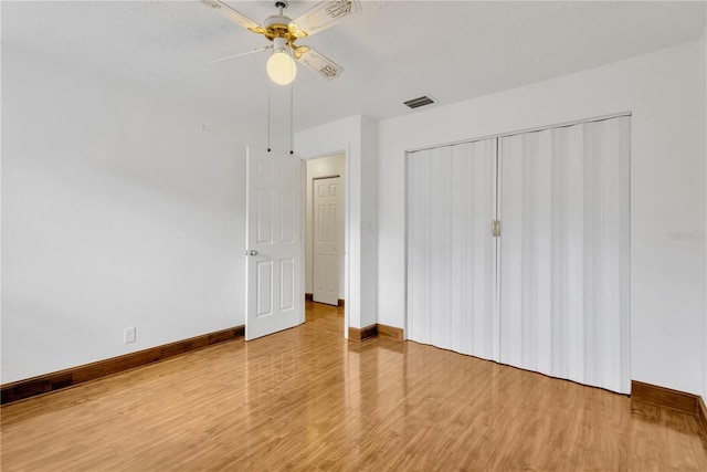 unfurnished bedroom featuring hardwood / wood-style floors, a textured ceiling, a closet, and ceiling fan