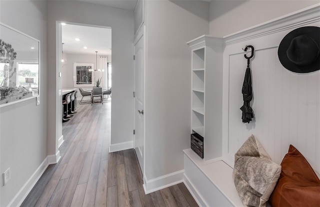 mudroom with a chandelier and hardwood / wood-style flooring