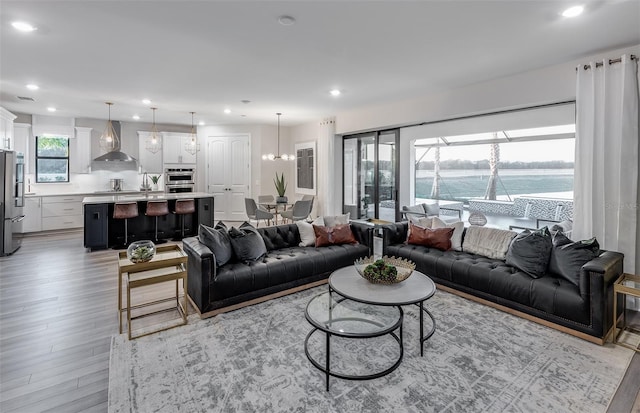 living room featuring a water view and light hardwood / wood-style flooring