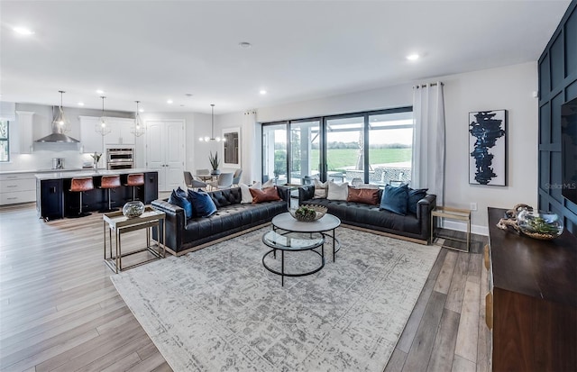 living room featuring light wood-type flooring and an inviting chandelier