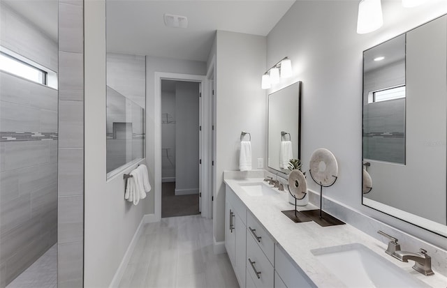 bathroom with vanity and a tile shower