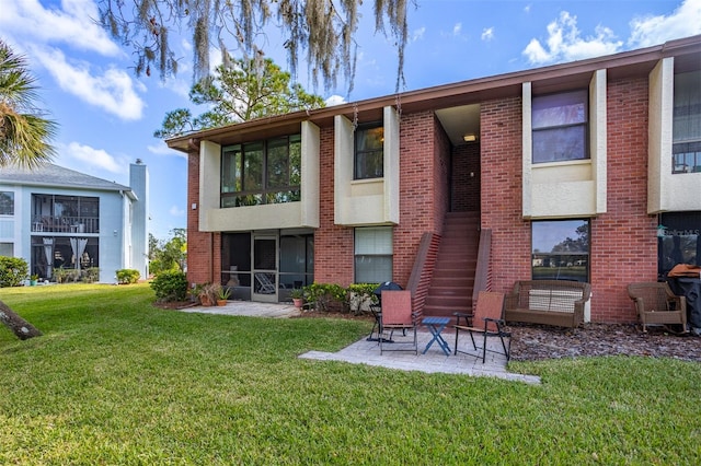 back of property with a lawn and a patio area