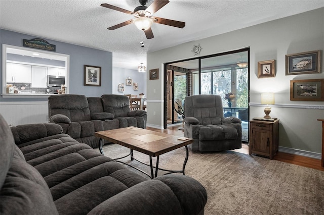 living room with hardwood / wood-style floors, ceiling fan, and a textured ceiling