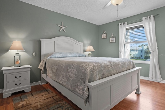 bedroom featuring ceiling fan, dark hardwood / wood-style floors, and a textured ceiling