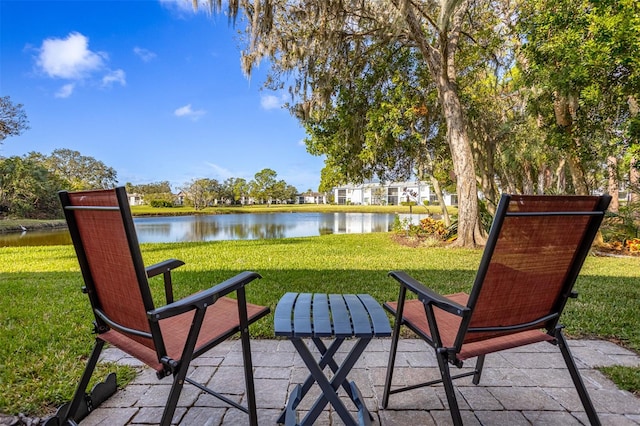 surrounding community featuring a water view, a yard, and a patio area